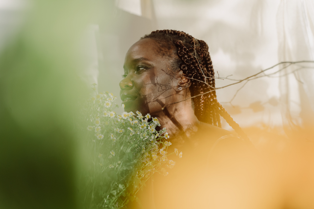 Braided Woman with a Bunch of Chamomile Flowers Near Her Face 