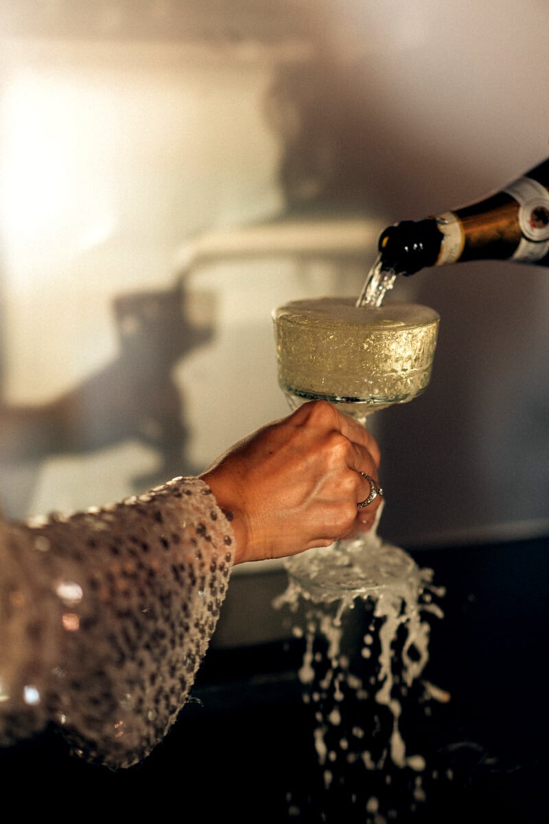 Person Pouring Champagne on Wineglass